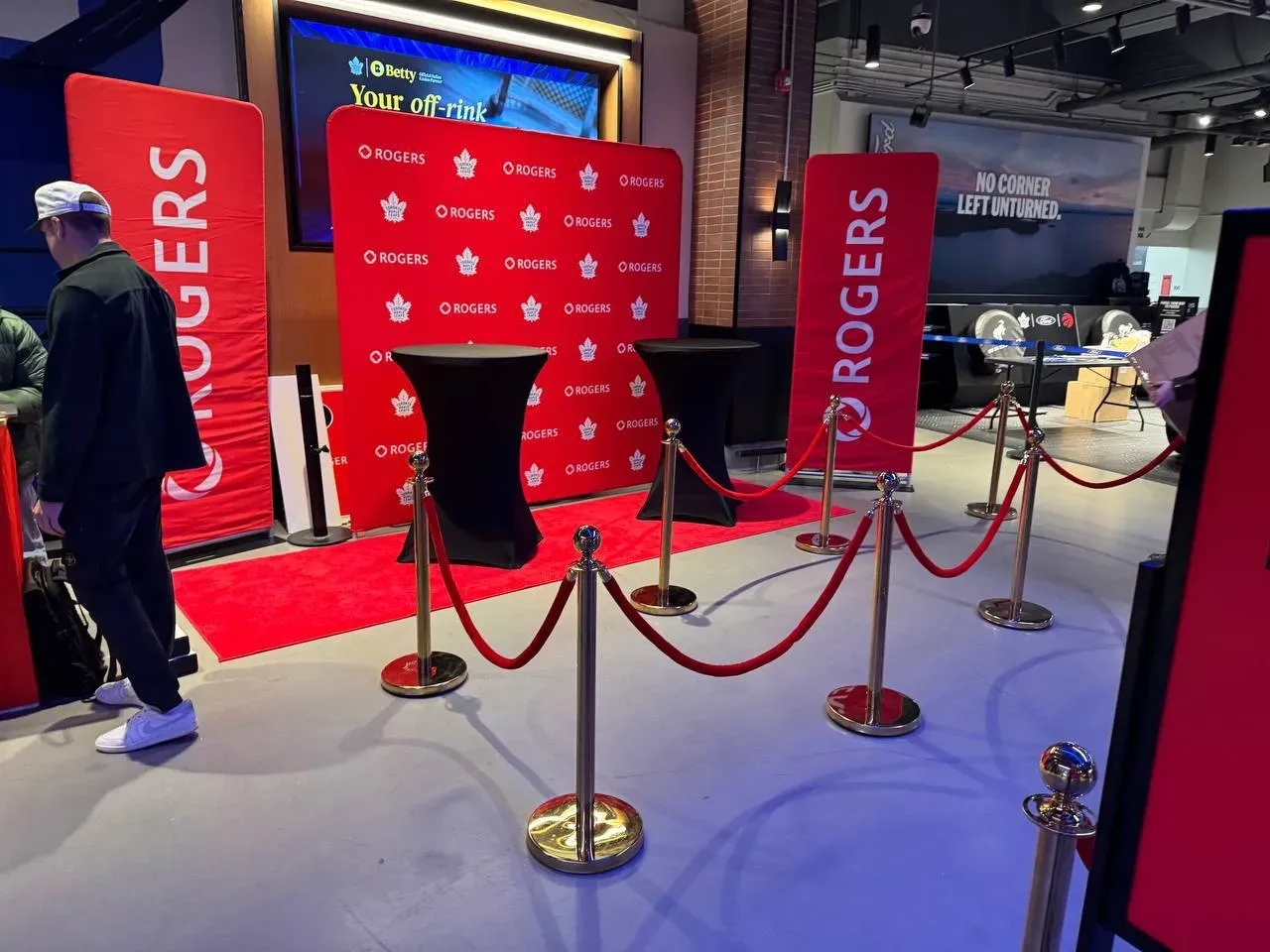 Gold rope stanchions with red velvet ropes framing a red carpet photo backdrop indoors